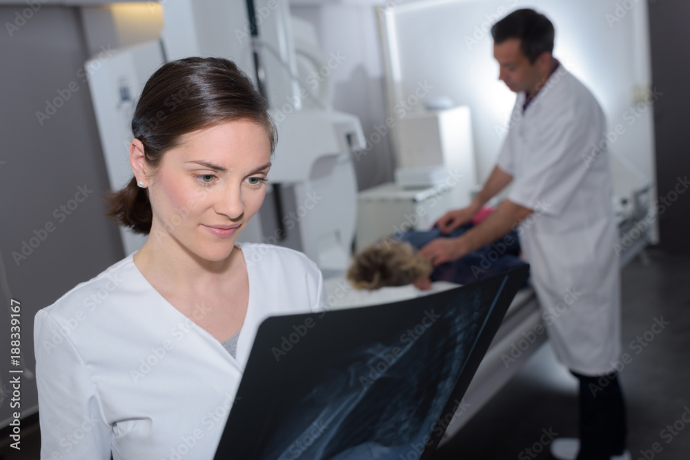 emale doctor looking at patients x-ray emale doctor looking at patients x-ray