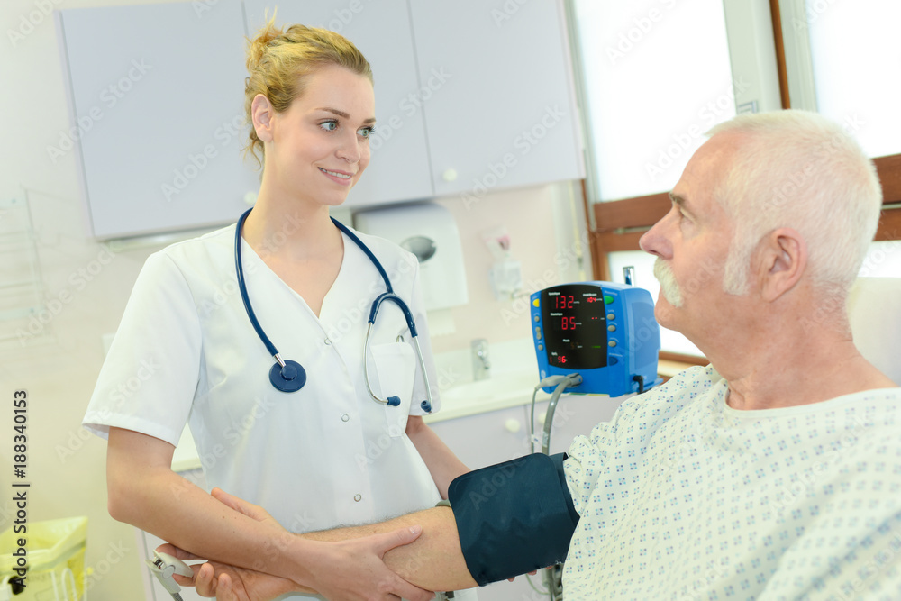 Φωτογραφία young female doctor checking blood pressure of senior male patient