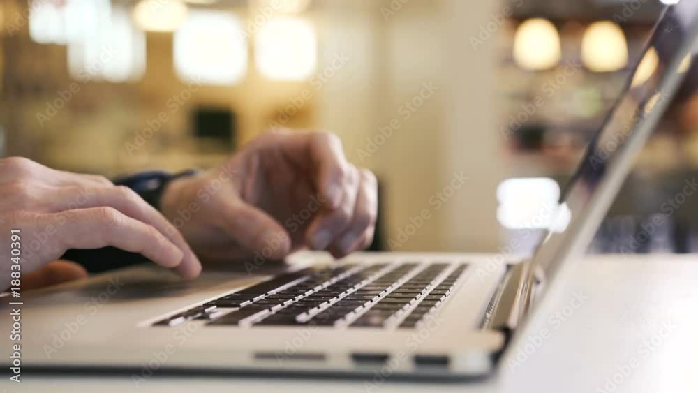 Man looks at email diagram and chart with a business plan and answers the business partner typing text on the laptop keyboard. Work communication in social networks with help of digital technologies