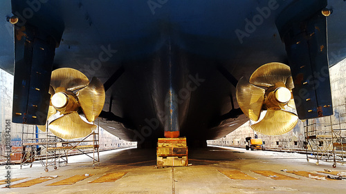 black ship hull and golden propeller at drydock