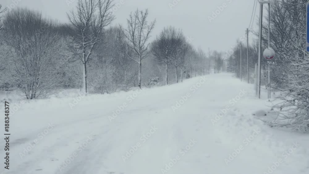 Snowy path with trails. Winter landscape with falling snow. Everything is covered with fresh powder. Intense atmosphere like Nordic detectives. Winter background for Christmas theme. Static day shot.