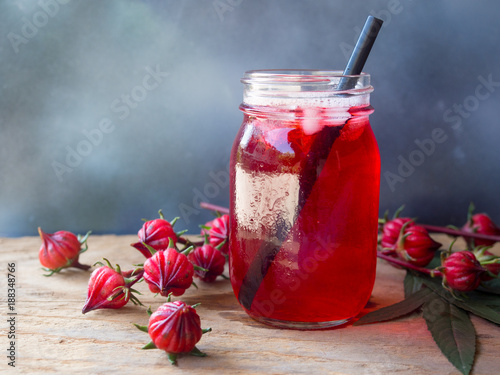 Tablou pe pânză Iced roselle tea glass  with fresh roselle fruit  on wooden table  for healthy herbal drink concept