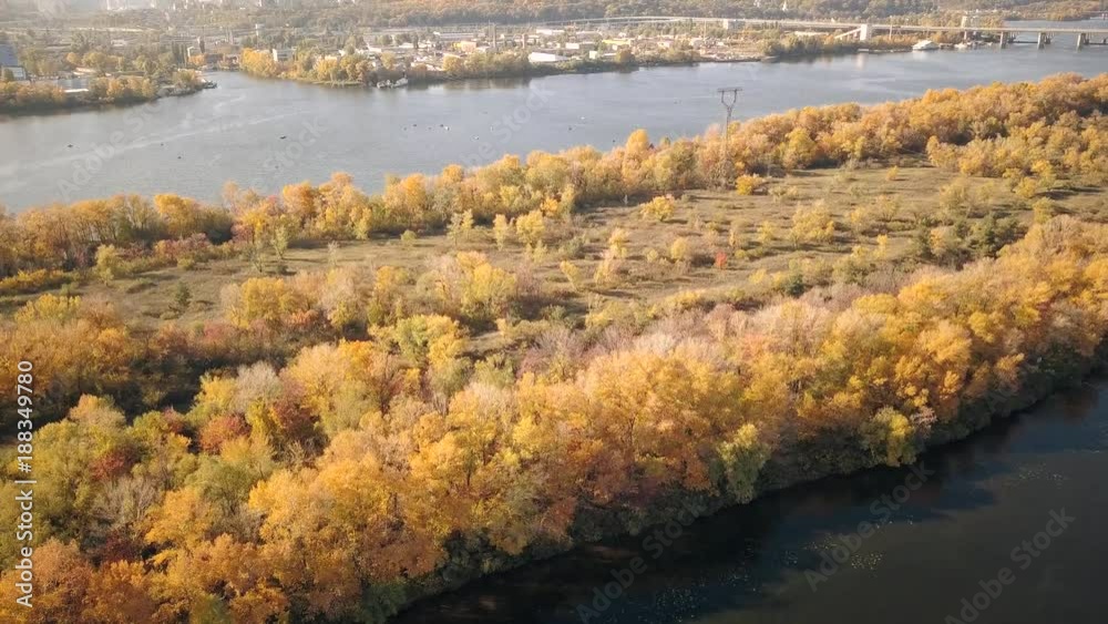 The city of Kiev is the Dnieper River. Autumn day the river. The leaves of the trees were covered with yellow leaves on the island. Aerial view. 4K The city of Kiev is the Dnieper River. Autumn day the river. The leaves of the trees were covered with yellow leaves on the island. Aerial view. 4K