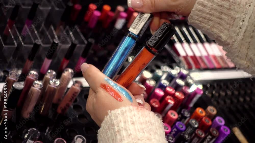 Shelf with cosmetics - lipstick, eye shadow - Woman shopping in a Mall - close-up no people
