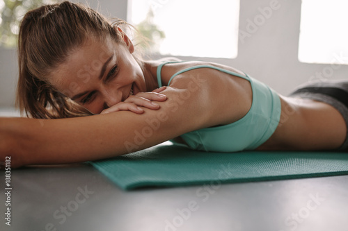 Happy young woman resting after exercise session at gym