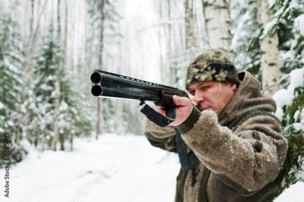 A hunter with a gun. Winter hunting. Huntsman.