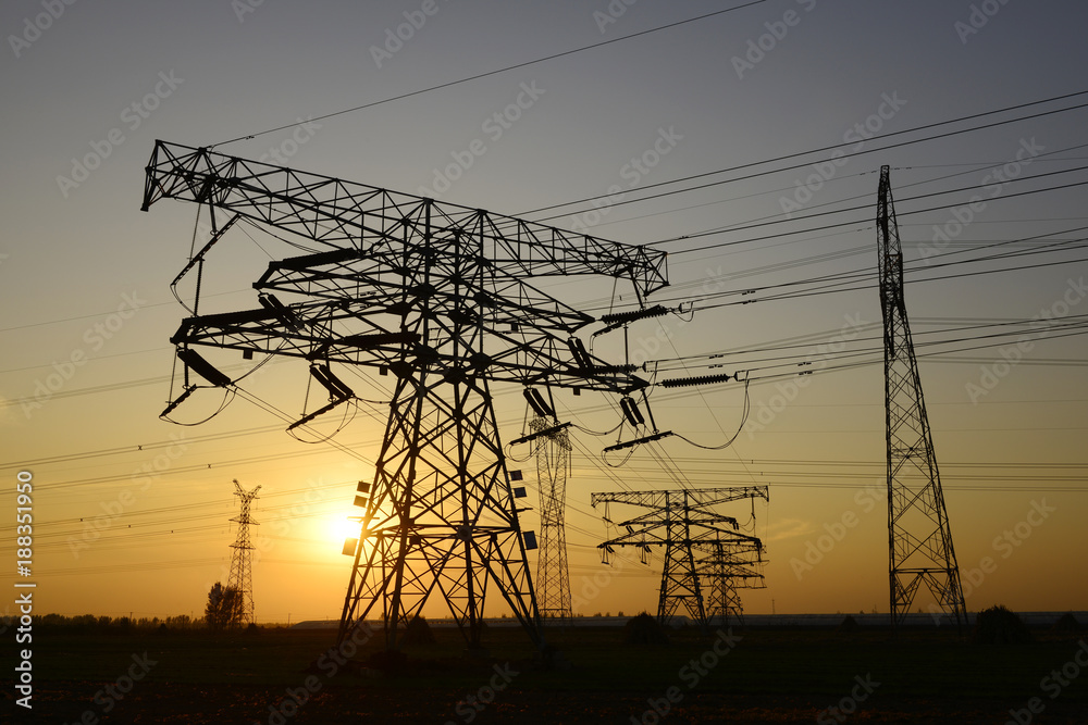 Fototapeta premium High voltage towers under the setting sun, close-up