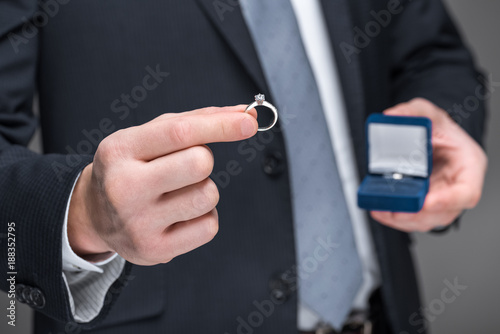 cropped view of man proposing with ring, isolated on grey