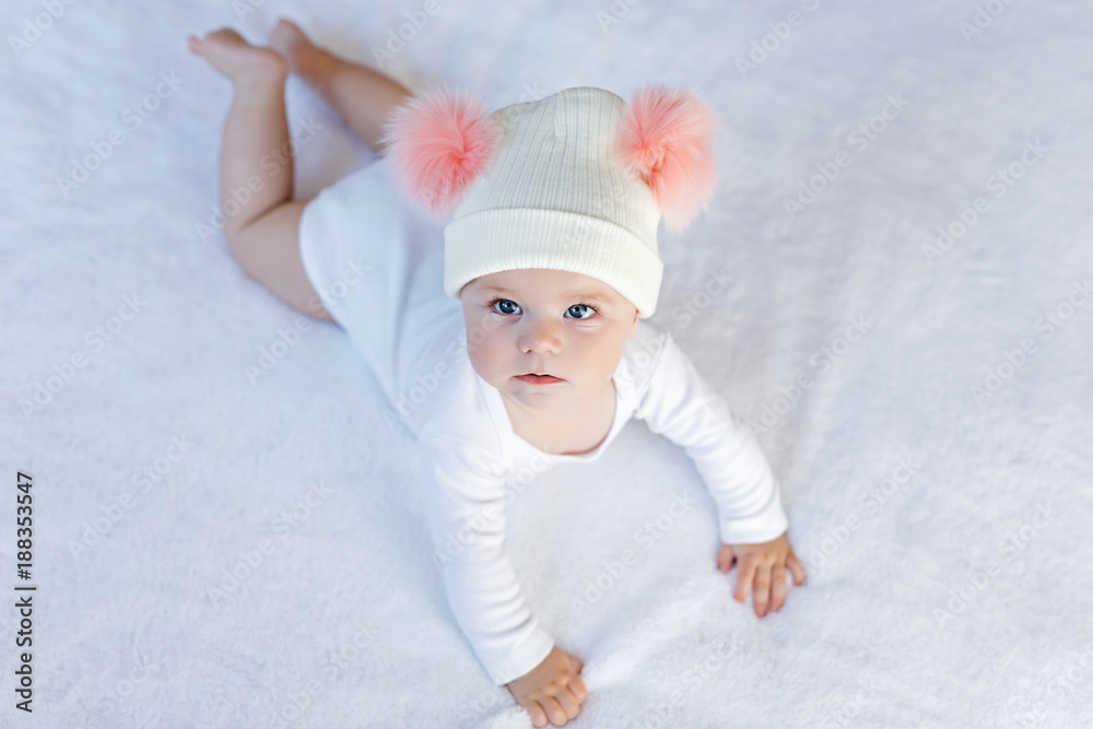 Cute adorable baby child with warm white and pink hat with cute bobbles Cute adorable baby child with warm white and pink hat with cute bobbles