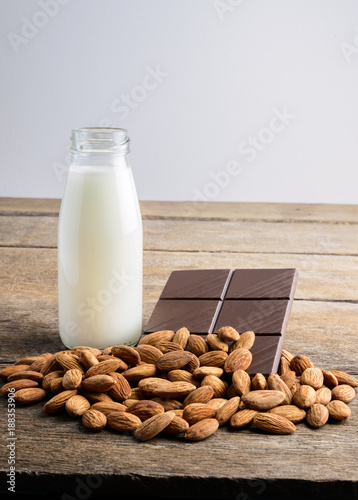 milk in bottle  chocolate and almond on wooden