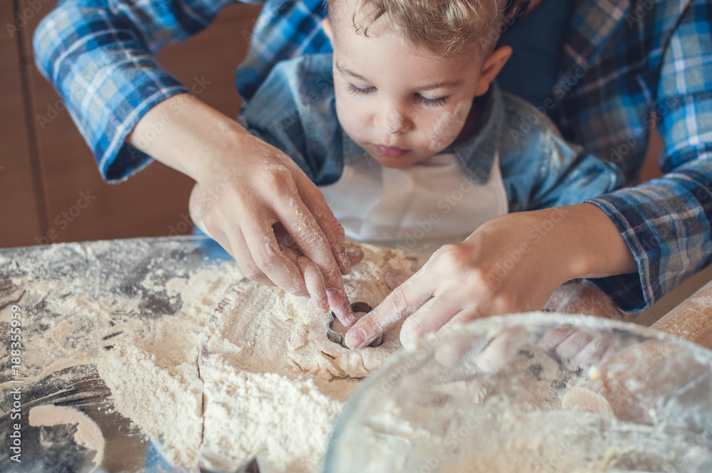 cropped image of mother and son making cookies with dough molds