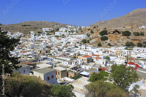 Small white houses on the mountains and blue sky background.