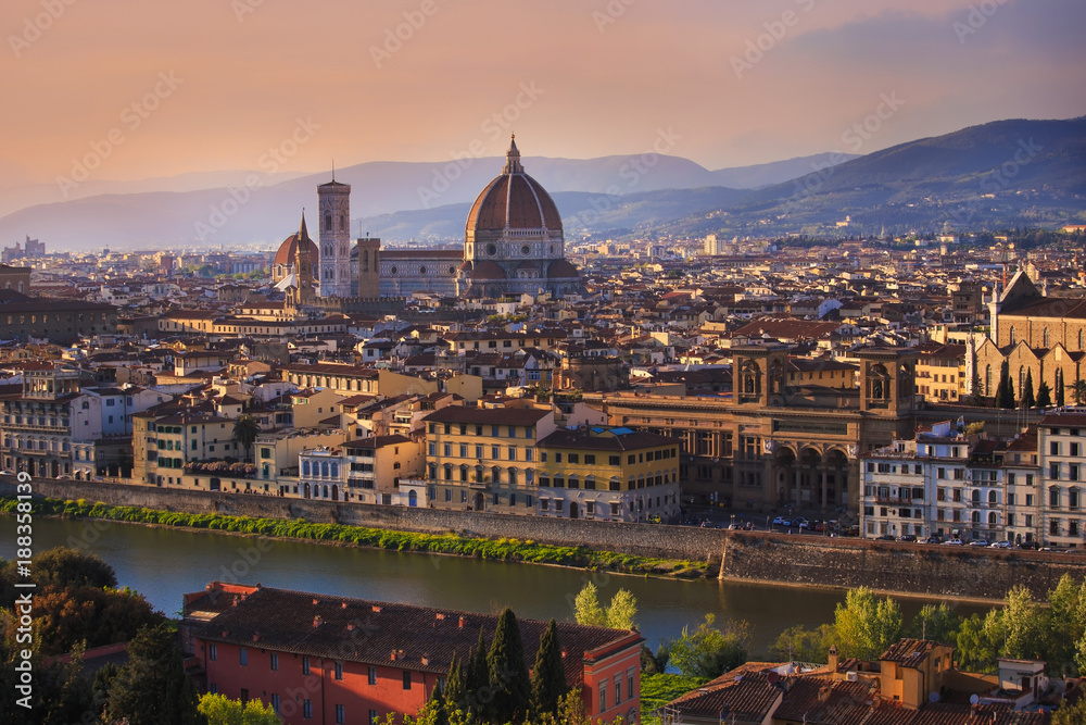 Panoramic view of Florence city during golden sunset which Florence from Michelangelo Square in the evening light in spring, a pilgrimage of tourists and romantics at Duomo Cathedral. Italy, Tuscany