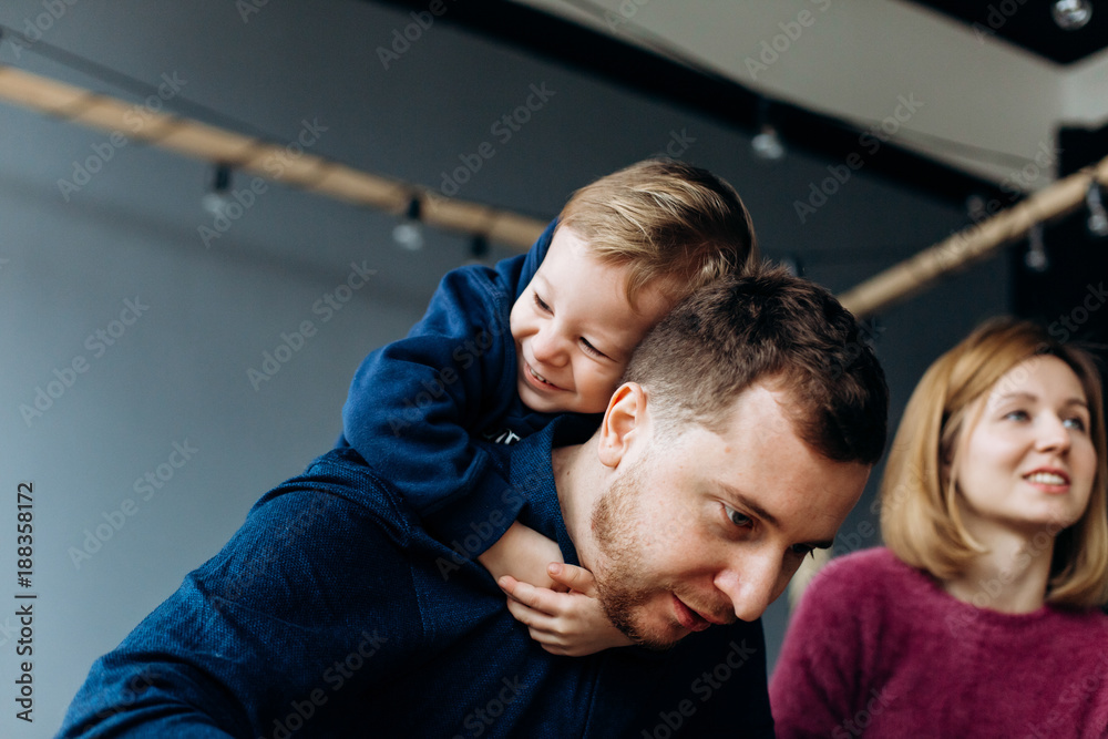 Father plays with little son in a cosy bright room