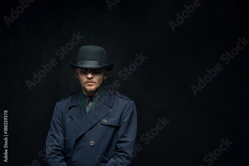 Serious man with a cold look in a hat on a dark background