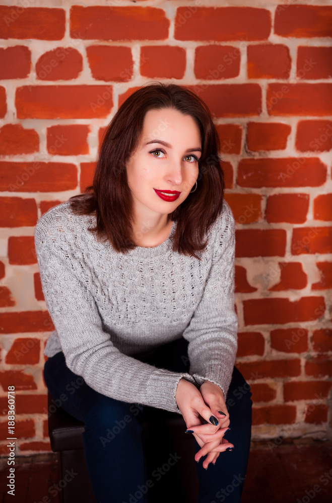 beautiful girl in the studio on a red brick happy background on holidays and enjoys a pomp beautiful girl in the studio on a red brick happy background on holidays and enjoys a pomp