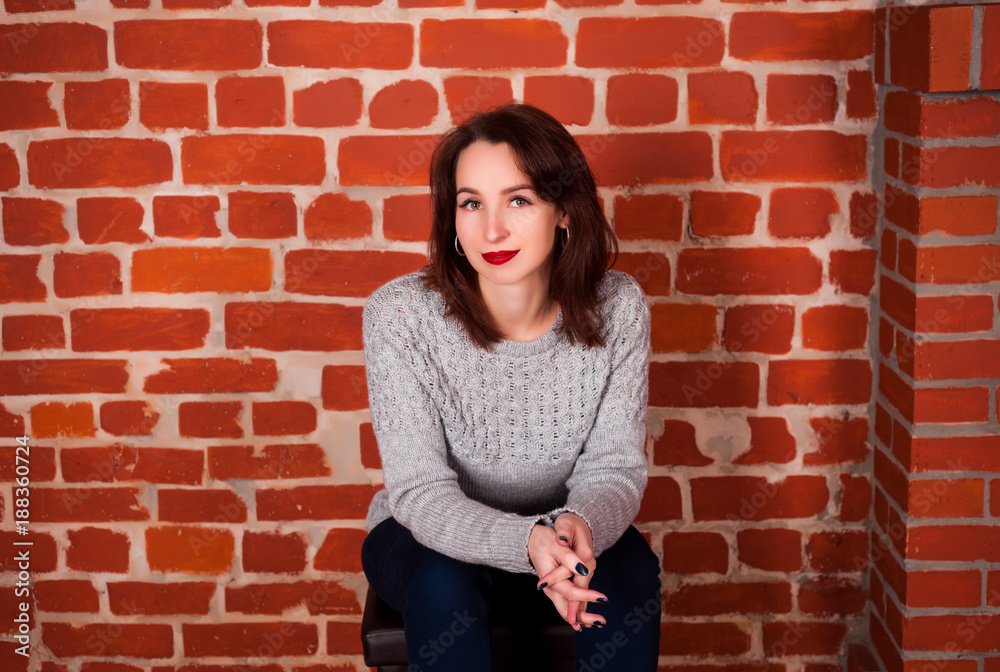 beautiful girl in the studio on a red brick happy background on holidays and enjoys a pomp beautiful girl in the studio on a red brick happy background on holidays and enjoys a pomp