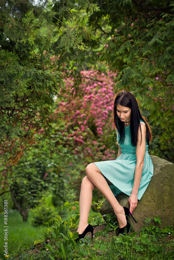 The girl walks around the park in her dress The girl walks around the park in her dress
