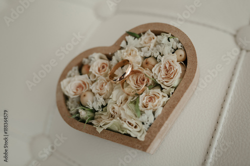 Beautiful wedding rings lie on background of a bouquet of flowers photo