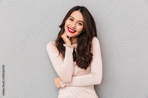 Картината върху платно Image of gorgeous brunette female model with long hair and red lips posing on ca