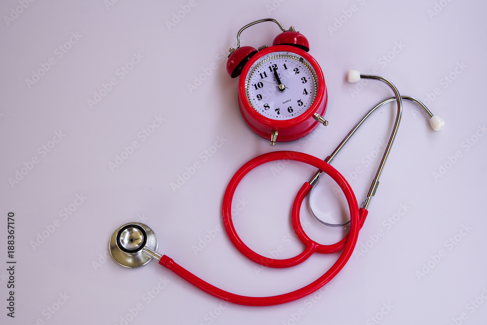 A red stethoscope kit and red bell clock.Time is important in life A red stethoscope kit and red bell clock.Time is important in life
