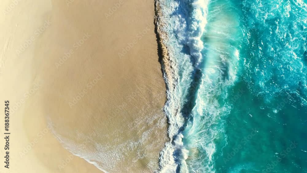 Aerial view waves break on white sand beach. Sea waves on the beautiful beach aerial view drone 4k shot. 