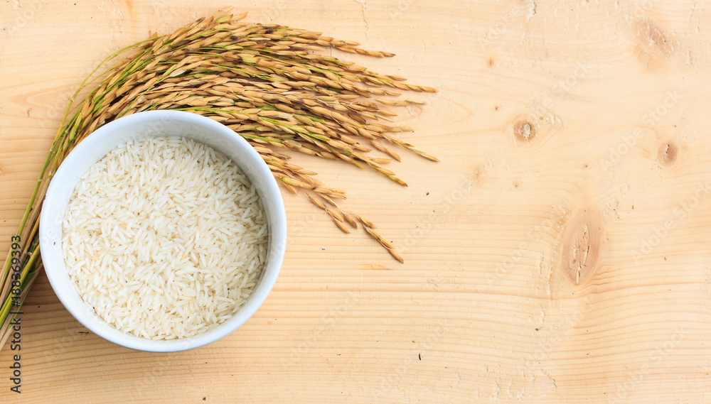 rice in bowl and ear of paddy on wooden. rice in bowl and ear of paddy on wooden.