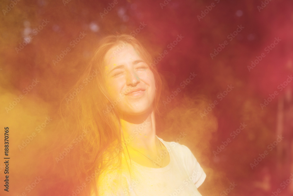 Expressive young woman having fun at Holi paint party