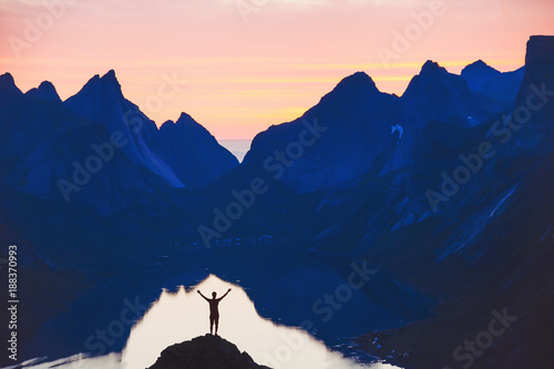 people and nature, silhouette of person with raised hands on beautiful mountain landscape at sunset