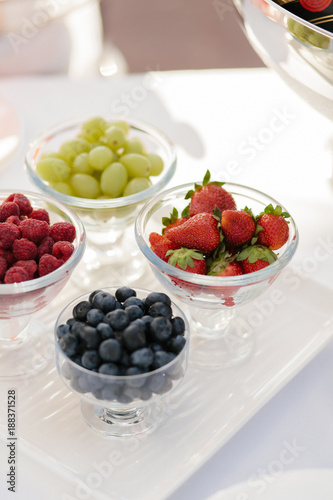 Strawberry , raspberry , blueberry on the background of carnation flowers photo