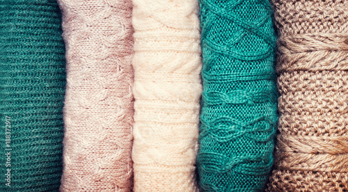 Obraz na plátně Pile of knitted wool sweaters on white background with copy space