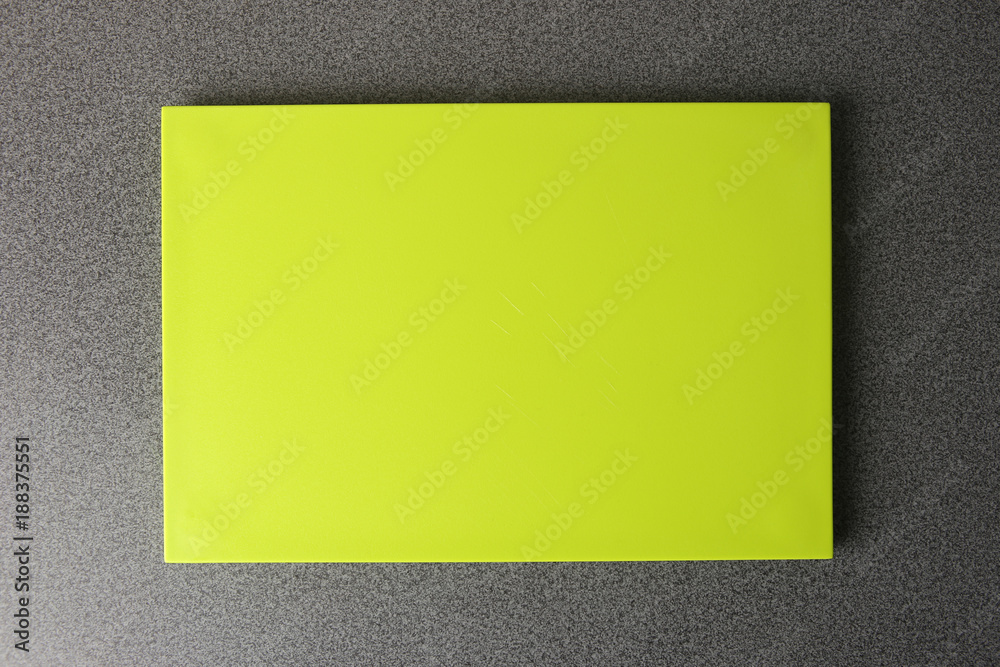 Bright green cutting board on table, top view. Cutting board with empty place for your design. Bright green cutting board on table, top view. Cutting board with empty place for your design.