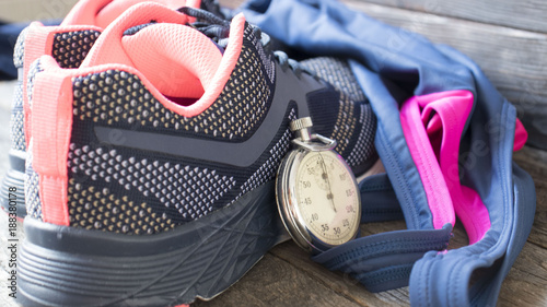 running shoes and stopwatch on wooden backgroundTime for fitness. photo