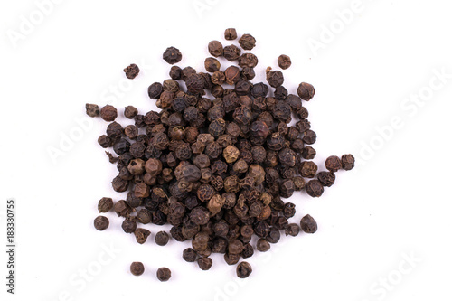 A pile of a dry black pepper seeds isolated on white background