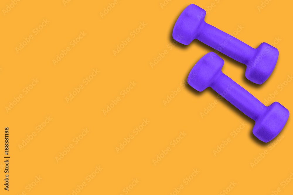 Pair of dumbbells of color ultra violet 18-3838 on a yellow background Pair of dumbbells of color ultra violet 18-3838 on a yellow background