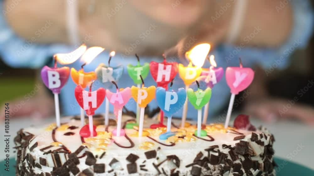 A woman blowing out candles on a cake. Birthday, cake with candles.