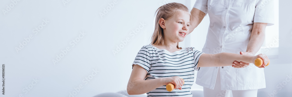 Smiling girl exercising with dumbbells Smiling girl exercising with dumbbells