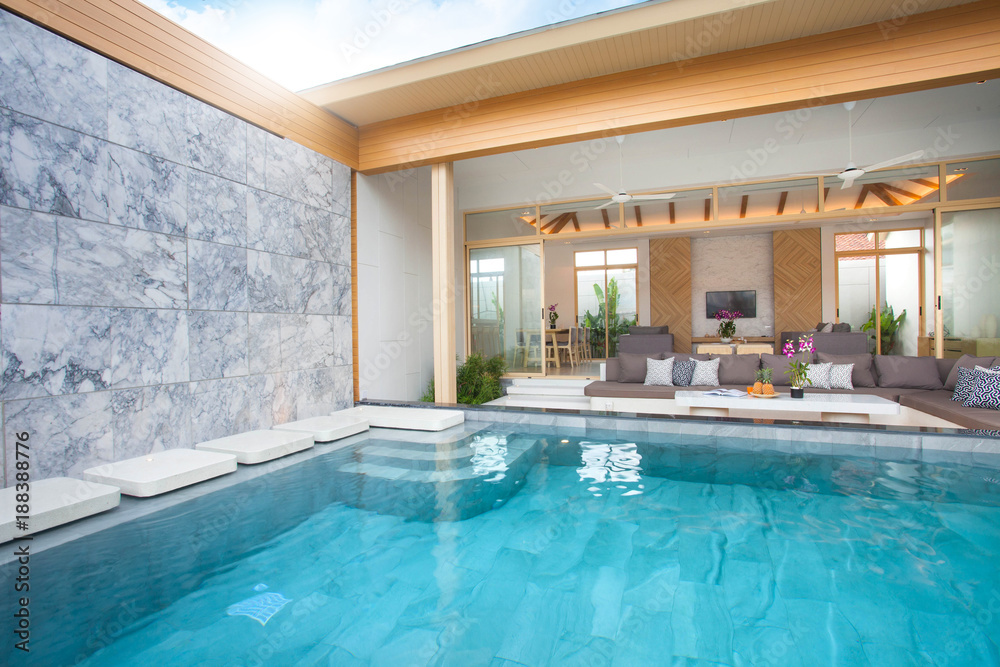 Luxury interior design in living room of pool villas. Airy and bright space with high raised ceiling and wooden dining table