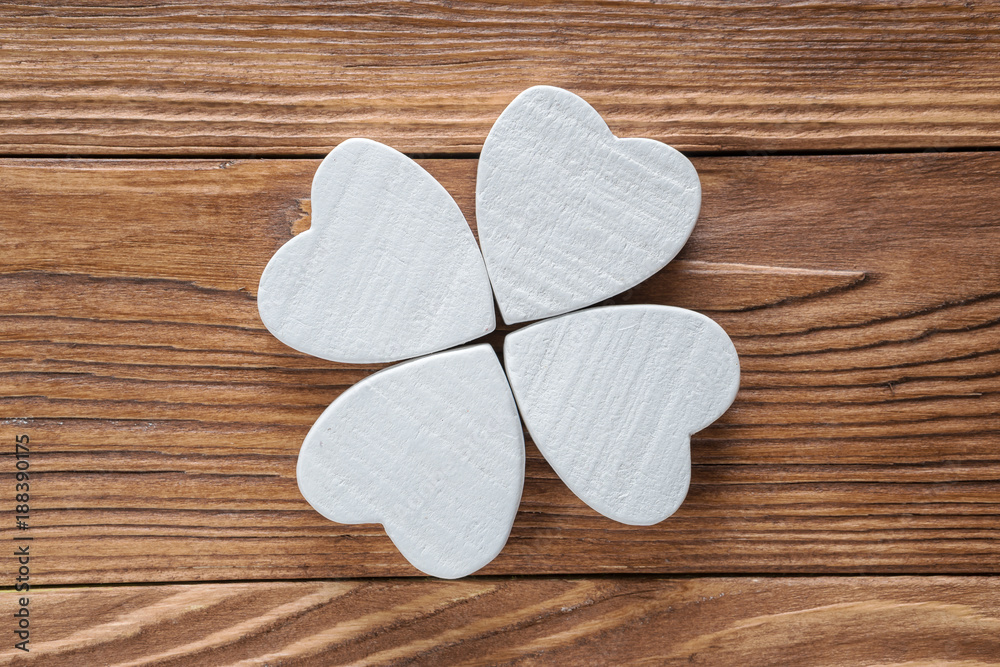 Fototapeta premium Abstract clover on wood background, top view, flat lay. Abstract white wooden clover, close-up.