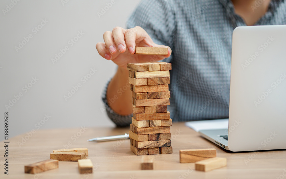 close up businessman hand holding wooden block for playing created tower , business vision concept
close up businessman hand holding wooden block for playing created tower , business vision concept