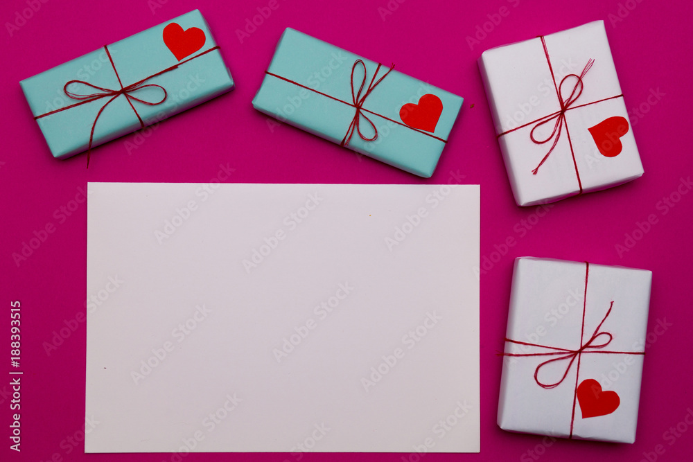 Happy Valentines day composition: white blank of paper with love gift boxes on pink background, photo template. Top View. View from above.