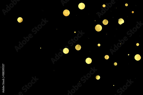 Golden confetti isolated on black background. © Vialeta