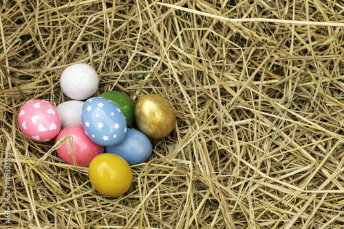  multiple eggs in the straw stack. Easter eggs Pink, yellow, green, yellow, straw Easter Day.
