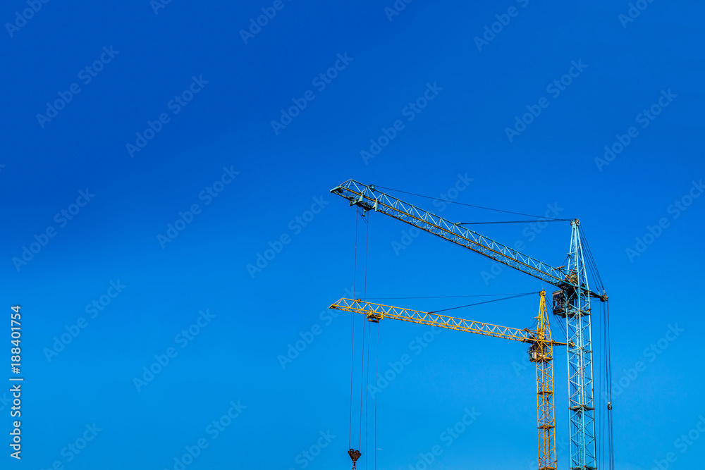 Two cranes against the blue sky.