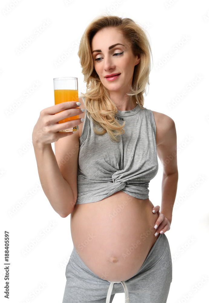 Beautiful pregnant woman hold fresh orange juice in hand ready to drink. Pregnancy motherhood expectation healthy eating Beautiful pregnant woman hold fresh orange juice in hand ready to drink. Pregnancy motherhood expectation healthy eating