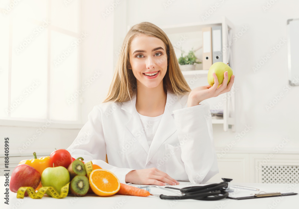 Smiling nutritionist woman with apple at office Smiling nutritionist woman with apple at office
