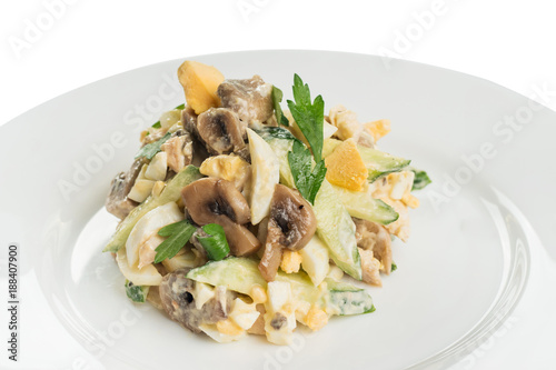 salad of fresh vegetables, boiled eggs and fried mushrooms, with mayonnaise on a white plate