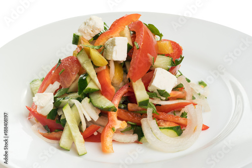 salad of fresh tomatoes, cucumbers and sweet pepper on a white plate