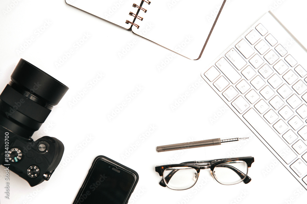 Notebook,spectacle,pinecones,pen,computer keyboard and mouse on white office desk.Top view with copy space.Flat lay of work desk. Notebook,spectacle,pinecones,pen,computer keyboard and mouse on white office desk.Top view with copy space.Flat lay of work desk.