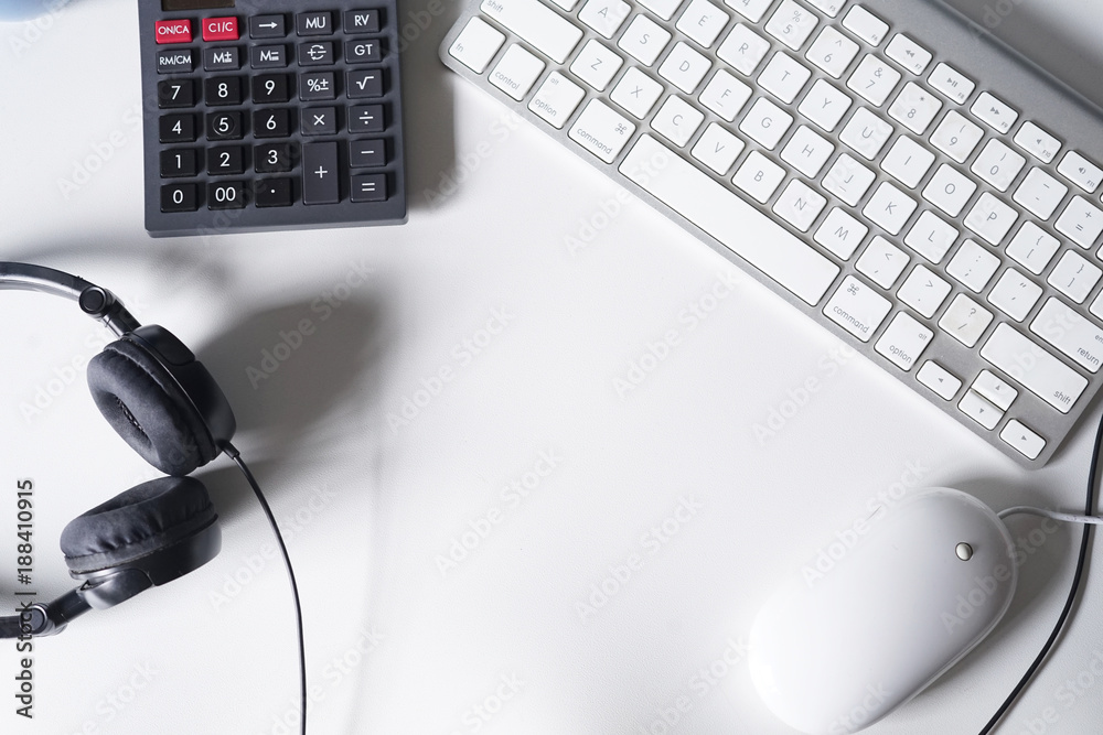 Headphone,smartphone,pinecones,calculator and computer keyboard on white office desk.Top view with copy space.Flat Lay shot. Headphone,smartphone,pinecones,calculator and computer keyboard on white office desk.Top view with copy space.Flat Lay shot.